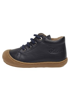 Navyblaue Lederschuhe mit Gummisohle, runder Spitze und Schnürverschluss. Weiche Innenauskleidung und ein strukturiertes, leicht erhabenes Markenlogo als Akzent.