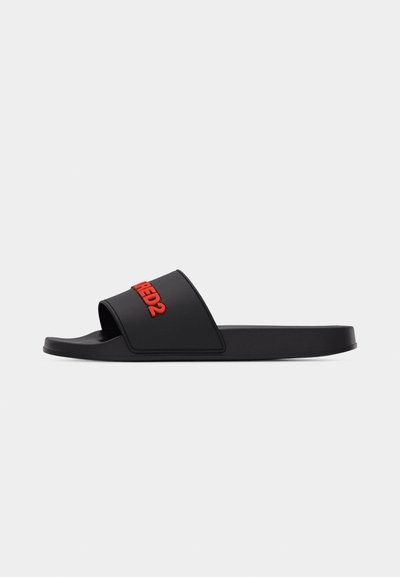 Sandale à glissière noire avec une large bride présentant le texte "DSQUARED2" en relief rouge, semelle plate, affichée sur un fond gris clair uni.