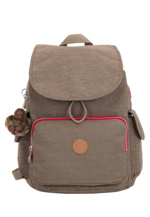 Brown fabric backpack with a flap closure, red accents, a front zip pocket, and a plush monkey keychain attached.
