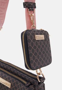Svart mönstrad handväska med guldfärgad hårdvara, med en avtagbar matchande liten påse. Remmarna inkluderar ett texturerat rosa tyg.