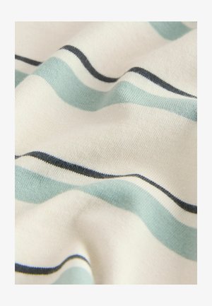 Puuvillane kangas lainemustriga, millel on hele sinised ja tumedad mereväe triibud kreemjal taustal, esitades sujuvat, tekstuuriga pinda.