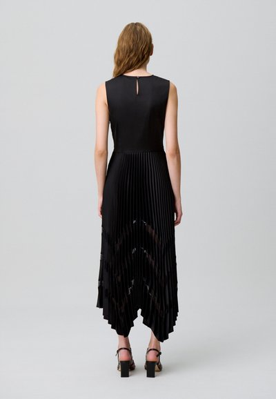 Vestido negro plisado con cuerpo ajustado, detalle de ojo de cerradura en la espalda y bajo asimétrico. Tela texturizada con detalles de encaje en la parte inferior.