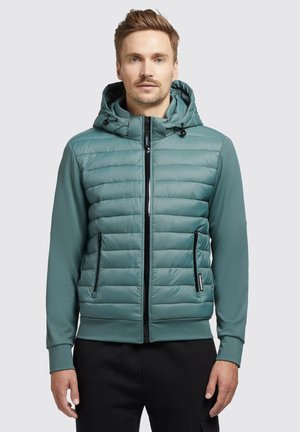  gepolsterte Jacke in Teal mit einem Reißverschluss vorne, verstellbare Kapuze und schwarzen Reißverschlusstaschen. Glatte Textur und taillierte Passform.