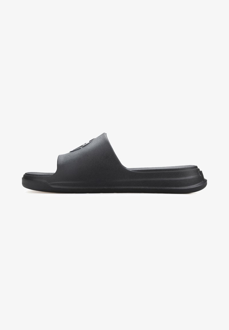 Black slide sandal made of matte rubber, featuring an open toe design and a textured footbed. The sole is flat with subtle grooving.