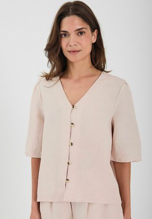 Blusa de lino rosa claro con mangas cortas, escote en V y una fila de cuatro botones dorados en la parte delantera. Textura suave y corte relajado.