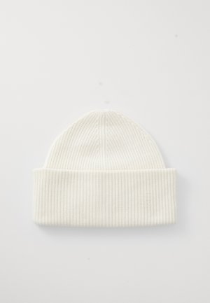 Bonnet en tricot blanc à côtes avec un revers, présentant un design sans coutures et une texture douce, idéal pour un usage décontracté par temps froid.