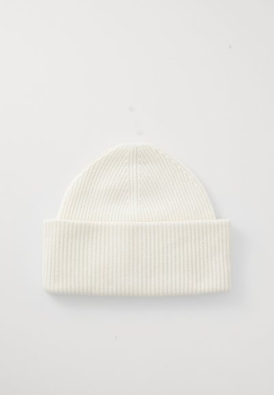 Berretto a costine bianche con risvolto, caratterizzato da un design senza cuciture e una consistenza morbida, adatto per un abbigliamento casual in inverno.