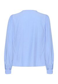 Camicia azzurro chiaro a maniche lunghe con una consistenza morbida, scollo rotondo e dettagli arricciati sulle maniche e sui polsini. Tessuto liscio con leggero rigamento.