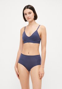 Ensemble de soutien-gorge sans fil bleu marine et de culottes taille haute, fabriqué en coton doux, avec un design minimaliste et de subtiles accents du logo de la marque.