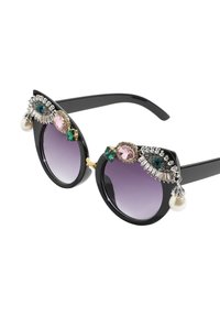 Occhiali da sole neri a forma di occhio di gatto con lenti viola sfumate, decorati con accenti di gioielli colorati e un dettaglio di perla sulla tempia sinistra.