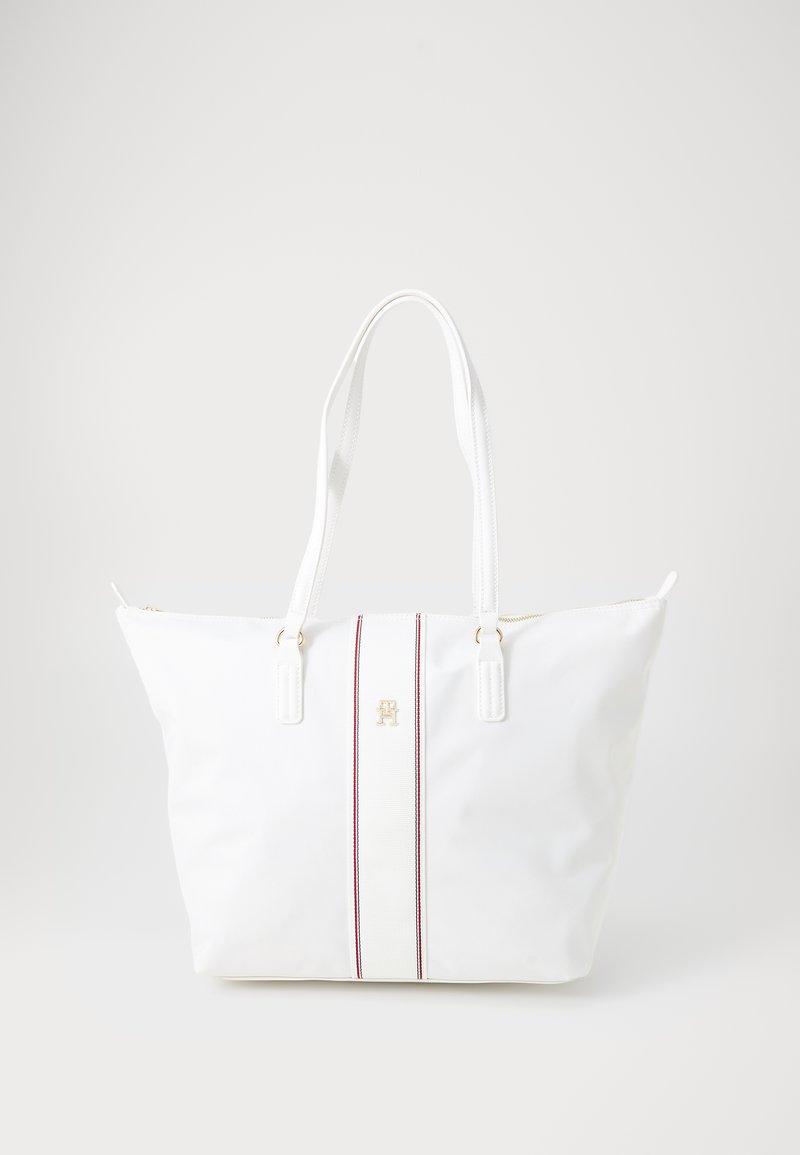 Sac fourre-tout blanc avec quincaillerie dorée, une bande centrale avec des accents rouges et double poignée supérieure. Texture lisse et fermeture zippée sur le dessus.