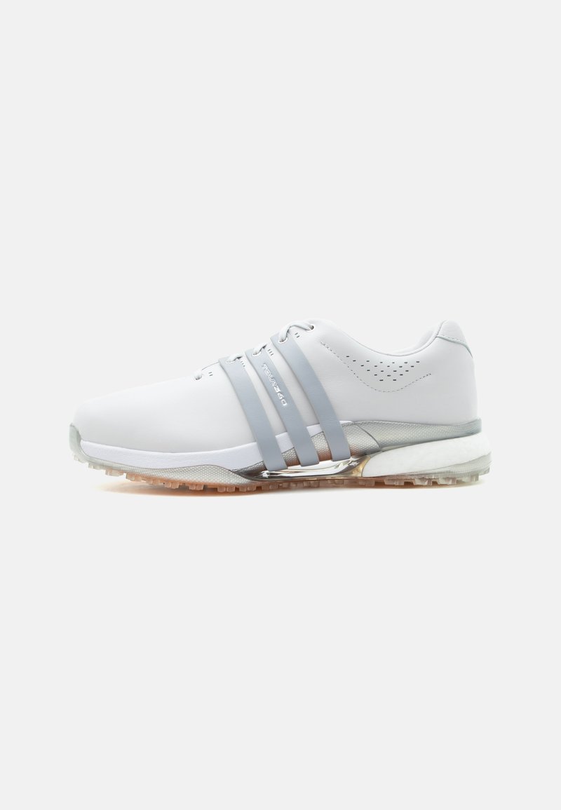 Λευκό αθλητικό παπούτσι με τρεις γκρι λωρίδες στο πλάι, τρύπες κοντά στη φτέρνα, υφή στη σόλα και αντανακλαστική λεπτομέρεια στη μέση της σόλας, σε λευκό φόντο.