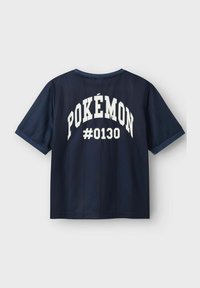 Temno modra majica s kratkimi rokavi in okroglo ovratnikom, na hrbtni strani pa se v velikih belih črkah nahaja "POKÉMON #0130" ter navpične črte.