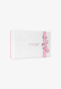 Hvit rektangulær gaveeske med preget blomsterdesign, rosa elastiske bånd, og teksten: "Lykken kan finnes i de minste ting."