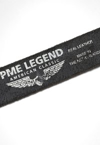Secteur de ceinture en cuir noir texturé avec le texte blanc "PME Legend American Classic," un emblème ailé, et "Cuir véritable fabriqué aux Pays-Bas."