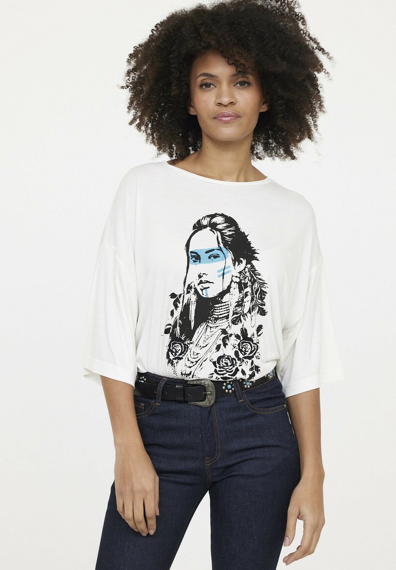 Weißes, übergroßes T-Shirt mit einem schwarz-blauen Grafikdruck einer Frau, die mit Blumen und Schmuck geschmückt ist. Mit aufgeschlagenen Ärmeln und Rundhalsausschnitt.