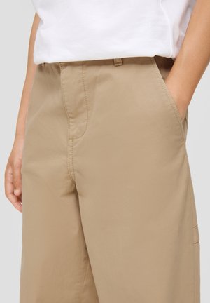 Beige broeken van lichtgewicht stof met een gladde textuur, voorzien van zijzakken en een plat voorpand ontwerp.