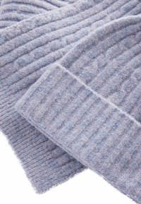 Écharpe en tricot côtelé bleu clair, fabriquée en laine douce, avec un motif texturé et un bord replié pour plus de détails.