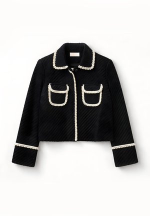 Chaqueta corta negra texturizada con mangas largas, dos bolsillos delanteros con solapa y ribete de cuentas blancas en el cuello, los bolsillos, el frente y los puños.
