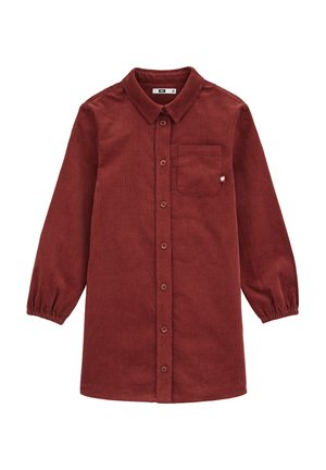 Chemise en velours côtelé d'un rouge profond, avec un devant à boutons, un col, de longues manches bouffantes et une poche sur la poitrine ornée d'un petit détail en forme de cœur.