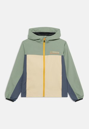 Hettejakke med grønn overdel, beige front, blå sidepaneler, elastiske mansjetter og gul frontglidelås, med Billabong Adventure Division-logo.