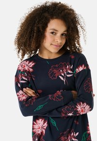 Granatowy sweter z długim rękawem w kwiatowy wzór, z różowymi i burgundowymi kwiatami oraz zielonymi liśćmi, wykonany z miękkiej mieszanki bawełny.