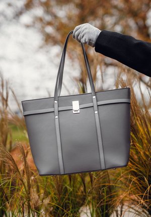 Grau Tote-Bag aus glattem Leder, ausgestattet mit doppelten Tragegriffen, silberfarbenen Beschlägen und einem minimalistischen Design mit zwei horizontalen Riemen.