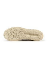 Semelle de chaussure en caoutchouc beige clair, avec une surface texturée comportant des motifs circulaires et ovales pour une meilleure adhérence et flexibilité.