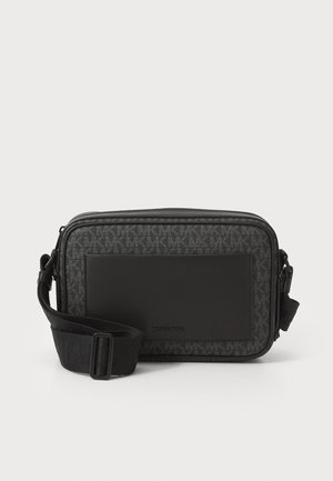 Bolsa transversal preta com um design de logótipo texturizado, detalhes suaves, fecho com zíper e alça ajustável. Mede aproximadamente 25 x 18 cm.