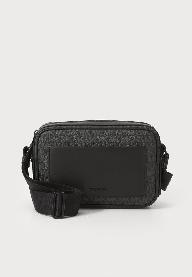 Sac de crossbody noir avec un design de logo texturé, des accents lisses, une fermeture éclair et une sangle ajustable. Mesure environ 25 x 18 cm.