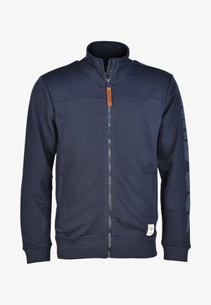 Marineblå zip-up jakke med ståkrave, sidelommer, en mærke-mærket lynlås, og logo-patch på den nederste venstre kant samt ærmestriber.