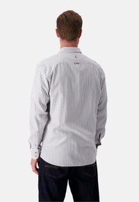 Camicia a maniche lunghe a righe grigia e bianca con polsini a bottone e orlo curvo, realizzata in tessuto leggero. Presenta un dettaglio sulla spalla posteriore.