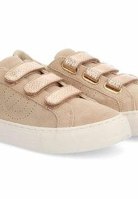 Sneaker beige in suede con tre fasce in velcro color oro rosa metallico, caratterizzate da dettagli in rilievo e una suola in gomma bianca.
