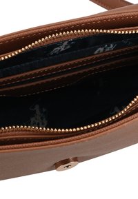 Borsa in pelle marrone con un esterno testurizzato, dettagli in cerniera dorata e un rivestimento interno scuro con un motivo sottile.