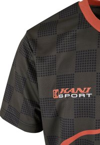 Tumša rakstota sporta krekla ar režģa dizainu, kas satur zvaigžņu formas. Oranžs apkakles kakls un logo kreisajā pusē. Izgatavots no elpojoša materiāla.