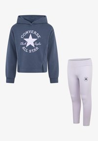 Blå hettegenser med hvit Converse-logo, paret med lyse rosa leggings med en liten logo. Begge laget av mykt stoff.