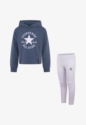 Blauwe hoodie met witte Converse-logo, gecombineerd met lichtroze leggings met een klein logo. Beide gemaakt van zachte stof.