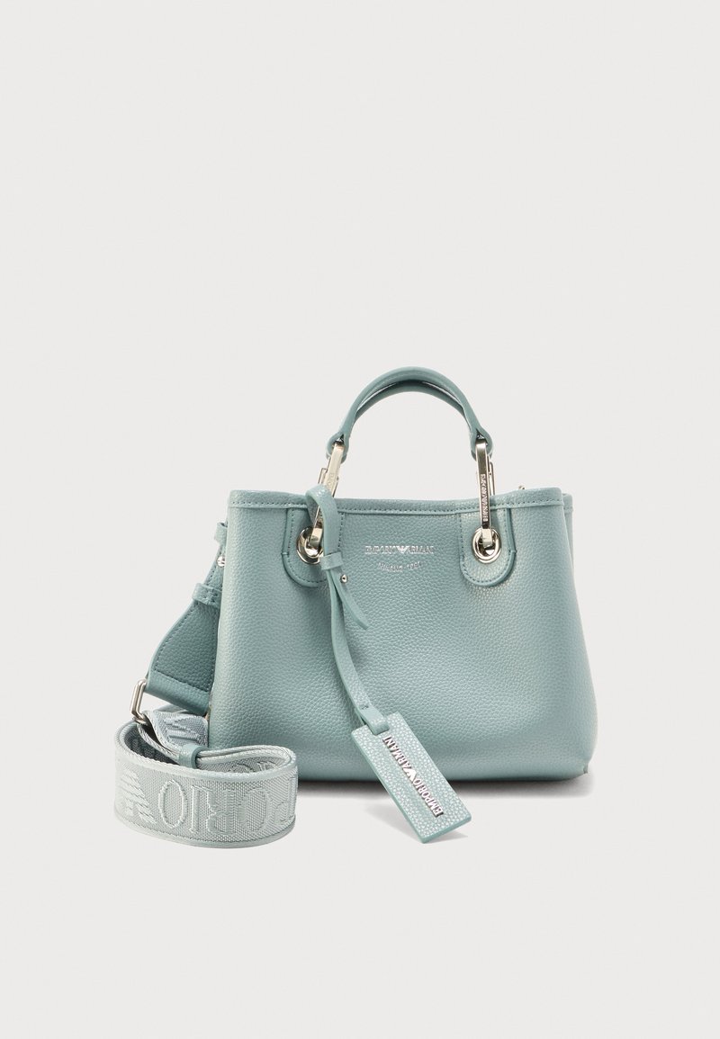 Δερμάτινη τσάντα ώμου σε ανοιχτό μπλε χρώμα με κοντά χερούλια, αποσπώμενο ιμάντα ώμου με λογότυπο και ασημένιες μεταλλικές λεπτομέρειες, απεικονισμένη σε λευκό φόντο.