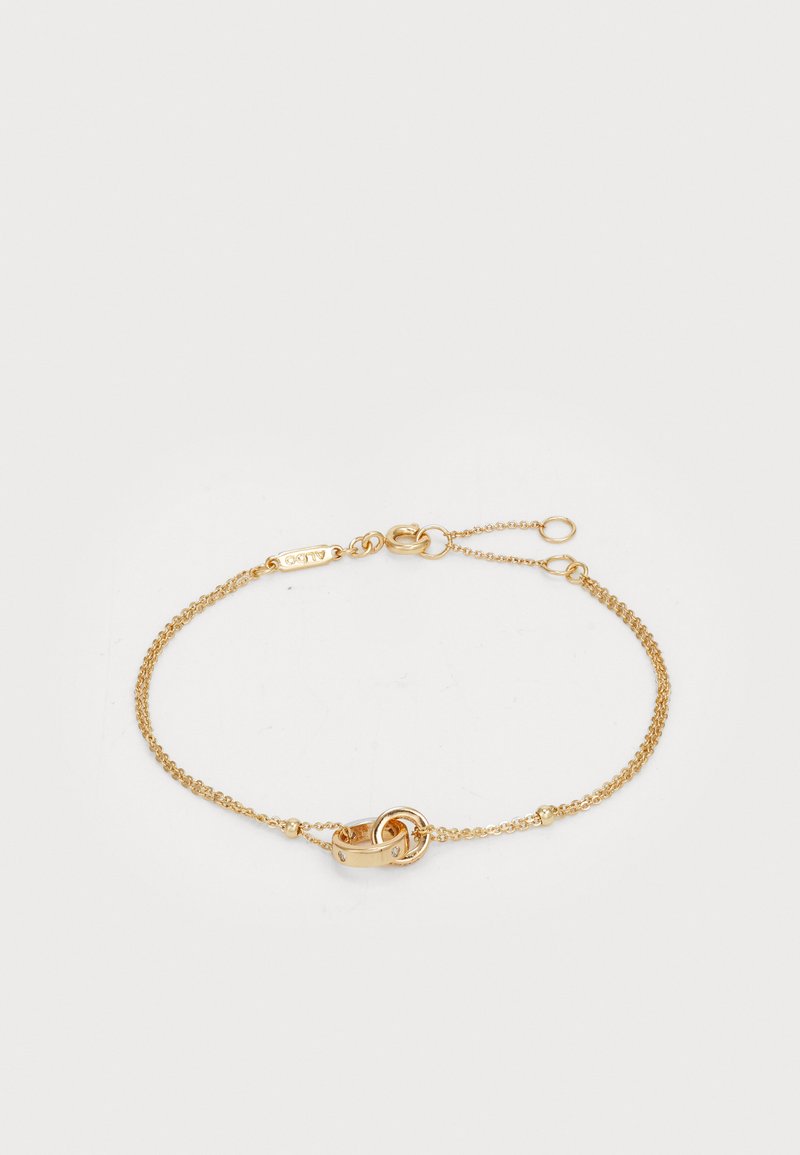 Gold chain bracelet featuring a delicate design with a central knot detail. Thin round links with a clasp closure, adjustable length.