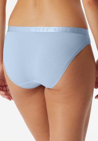 Ljusblå bomullstrosor med en glatt yta och ett tunt elastiskt midjeband med subtil präglad logotyp. Klassisk skärning och sömlös design.