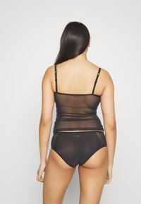 Zwarte doorschijnende camisole met verstelbare bandjes, gelaagd ontwerp, gecombineerd met bijpassend zwart doorschijnend ondergoed. Soepele textuur en eenvoudige silhouet.