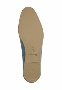 Semelle de chaussure en textile bleu avec une base en caoutchouc tan lisse, comportant des motifs texturés et le logo de la marque "TOMS" en bas.