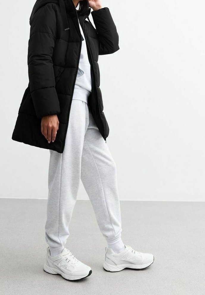 Musta toppatakki hupulla, harmaa puuvillainen collegepaita, harmaat collegehousut ja valkoiset urheilukengät mustilla yksityiskohdilla. Sileä pinta ja rento istuvuus.