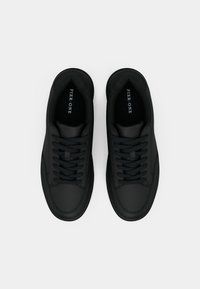 Μαύρα αθλητικά παπούτσια με απαλή ματ υφή, στρογγυλεμένο σχήμα, επίπεδα κορδόνια και μινιμαλιστικό σχεδιασμό. Διαθέτουν διακριτικό λογότυπο στο εσωτερικό.