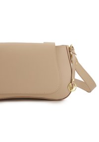 Beige Leder Crossbody-Tasche mit Klappenverschluss, goldfarbenen Hardware-Akzenten und verstellbarem Tragegurt. Glatte Textur und klare Linien.