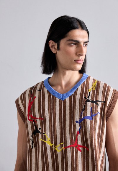 Gilet a maglia con strisce marroni e crema, colletto blu, caratterizzato da figure ricamate colorate in rosso, giallo, nero e blu.