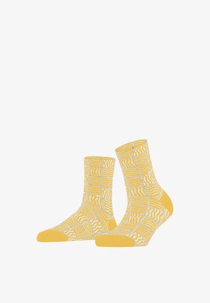 Gelbe Socken mit weißen und blassgrauen abstrakten Patchwork- und wellenförmigen Linienmustern, mit soliden gelben Zehen- und Fersenbereichen.