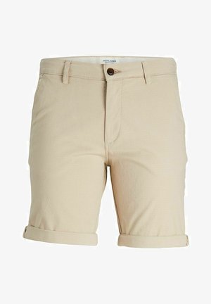 Shorts en coton beige avec une finition texturée, dotés d'une fermeture à bouton, de passants de ceinture et de manches retroussées. Étiquette de marque visible à l'intérieur.