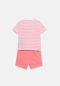 Κοντομάνικο πουκάμισο με λευκές και κοραλλί ρίγες, συνδυασμένο με μονόχρωμο κοραλλί σορτς που διαθέτει μικρή πίσω τσέπη και λογότυπο.