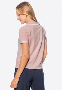 Polo tričko s krátkým rukávem v jasně růžové barvě s žebrovaným límcem a bílými akcenty. Měkká látka s volným střihem, s rovnými lemy.
